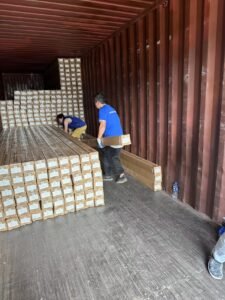 Workers are loading an order of baseboards onto a vehicle.