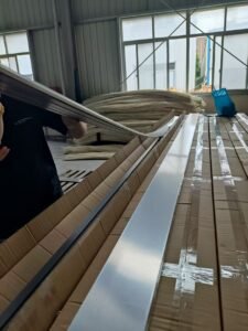 Worker handling skirting board profiles in production workshop